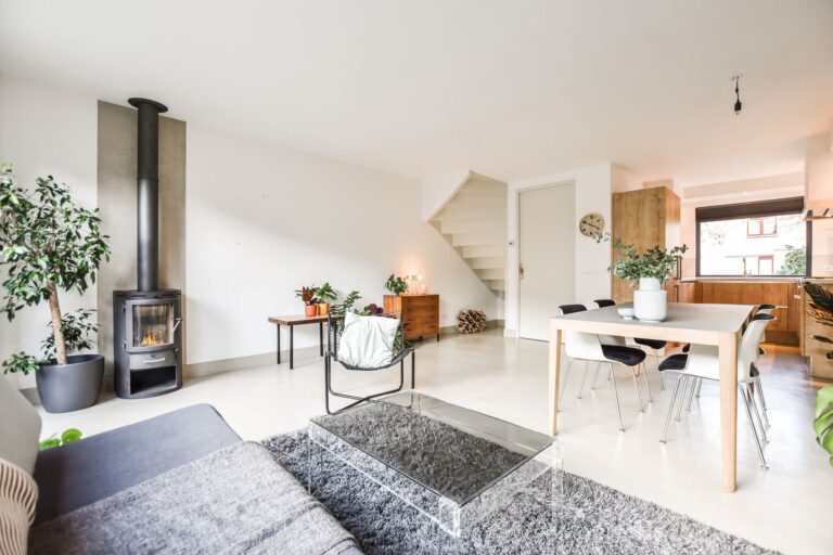 Helles Wohnzimmer mit Kamin, Esstisch, Treppe und moderner Einrichtung in einer 3-Zimmer-Wohnung.