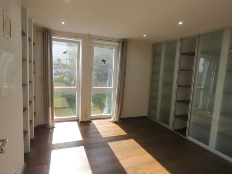 Heller Raum mit Parkettboden, großen Fenstern zum Garten und Einbauschränken in einer Wohnung in Bad Soden.